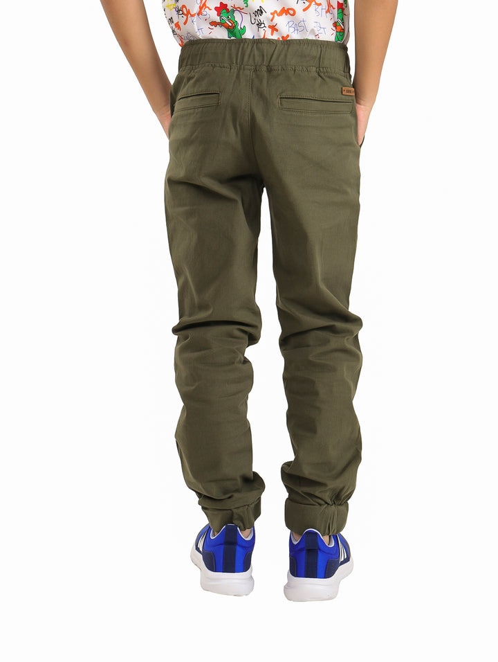 Pantalones tipo jogger color olivo para niño con cintura elástica y cordón ajustable.
