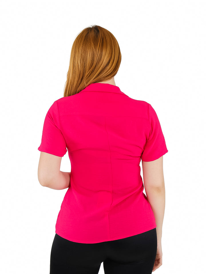 Mujer vistiendo blusa camisera color fucsia de manga corta y botones frontales.