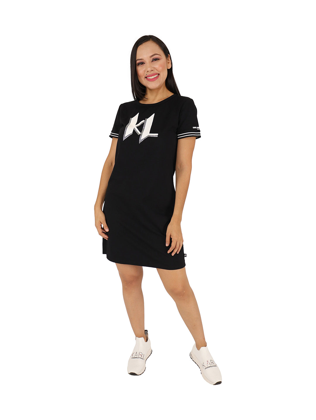 Mujer con vestido corto negro tipo camiseta con logotipo KL blanco en el pecho y detalles en mangas.