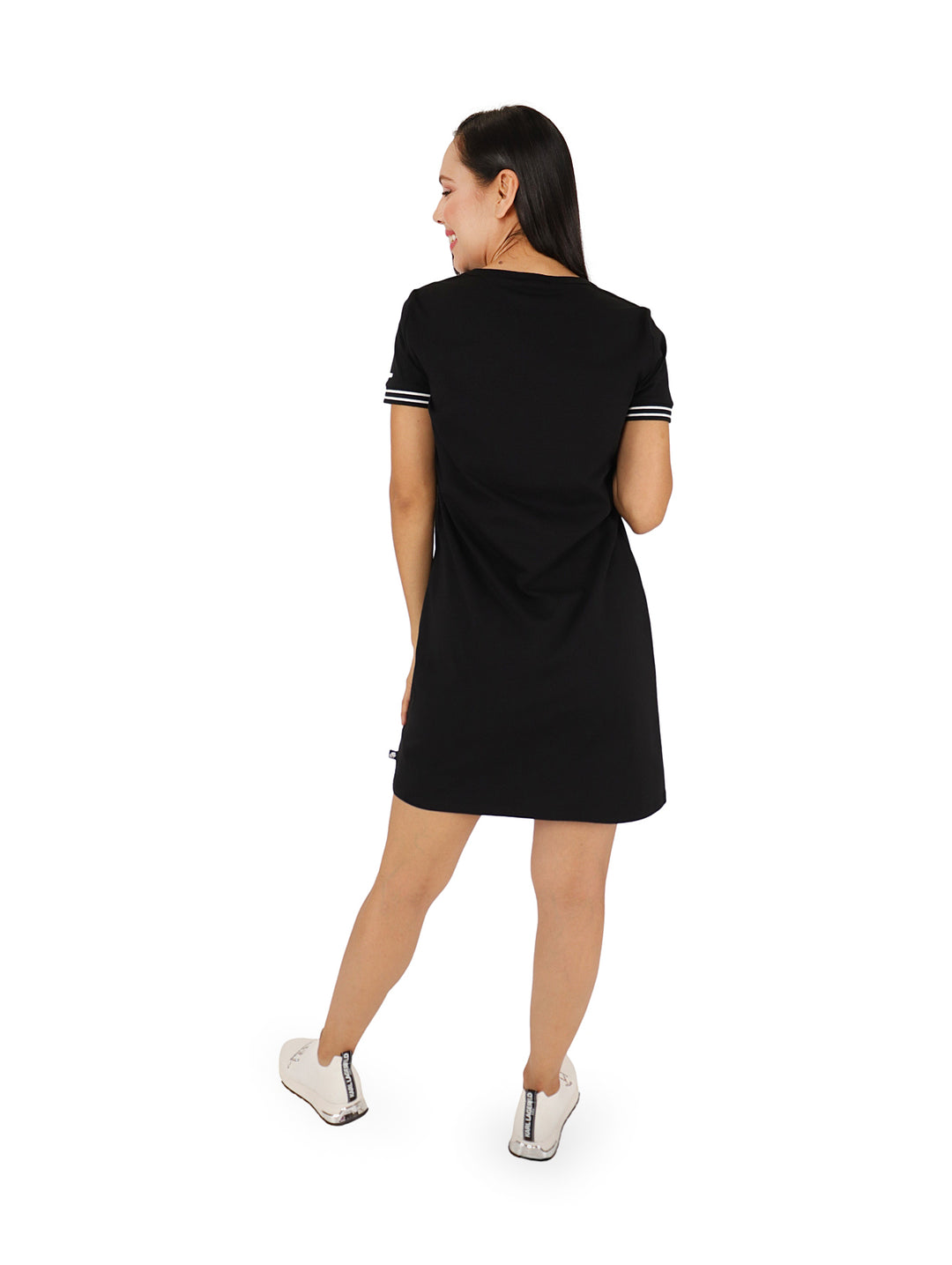 Mujer con vestido corto negro tipo camiseta con logotipo KL blanco en el pecho y detalles en mangas.