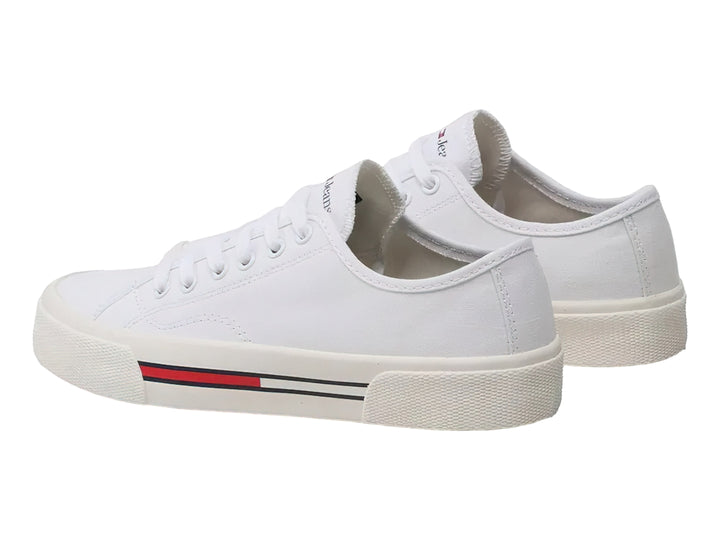 Tenis blancos de lona Tommy Hilfiger para mujer con detalle de franja roja y azul en la suela.