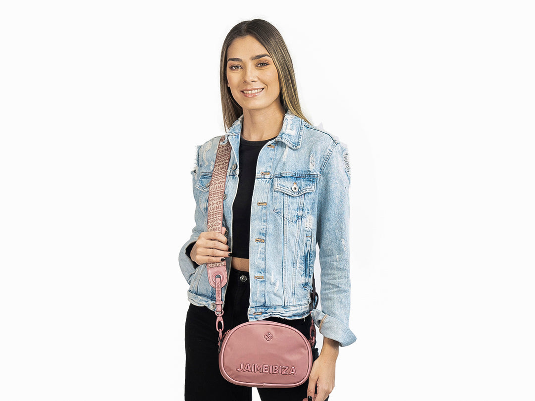 Bolso ovalado color blush de Jaime Ibiza con logo en relieve y correa ajustable.