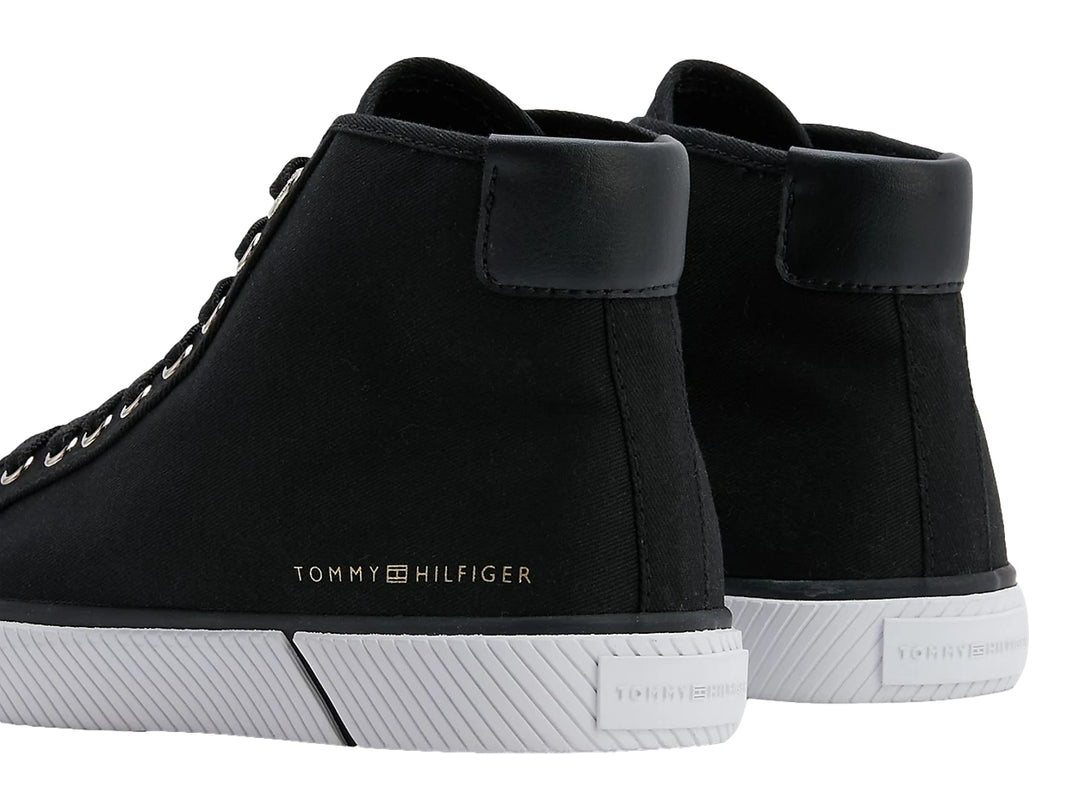 Tenis Tommy Hilfiger de corte alto en color negro con suela blanca y agujetas negras.