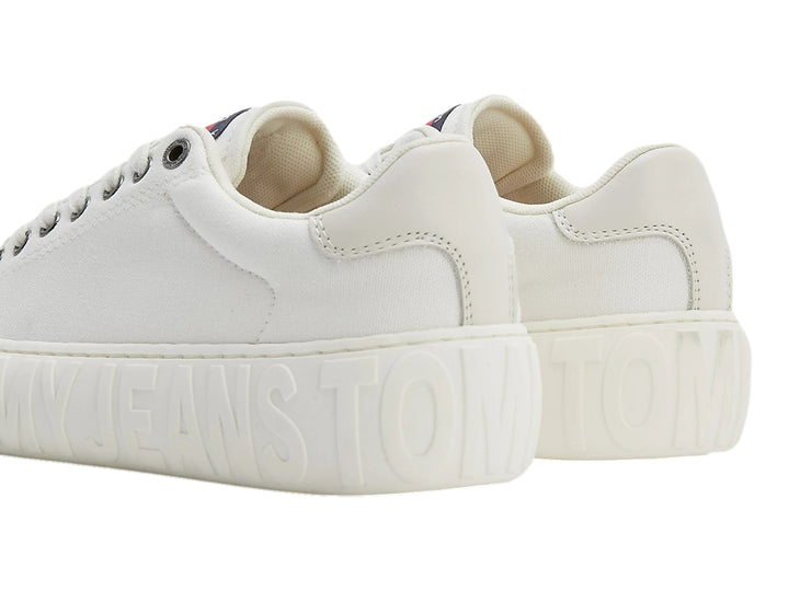Tenis blancos de lona Tommy Hilfiger con suela gruesa y texto grabado en relieve.