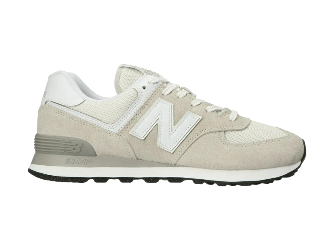 Tenis New Balance 574 color gris y blanco con detalles en gamuza y suela negra.
