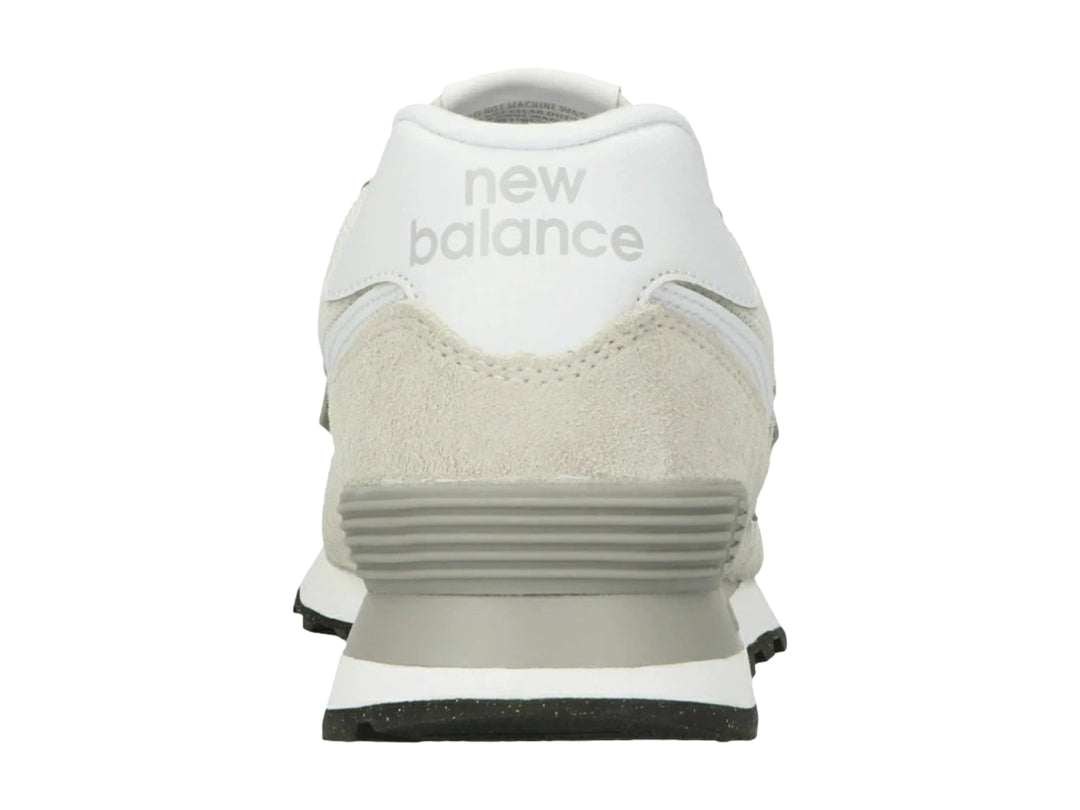 Tenis New Balance 574 color gris y blanco con detalles en gamuza y suela negra.
