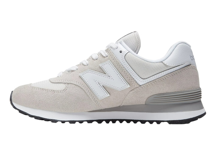 Tenis New Balance 574 color gris y blanco con detalles en gamuza y suela negra.