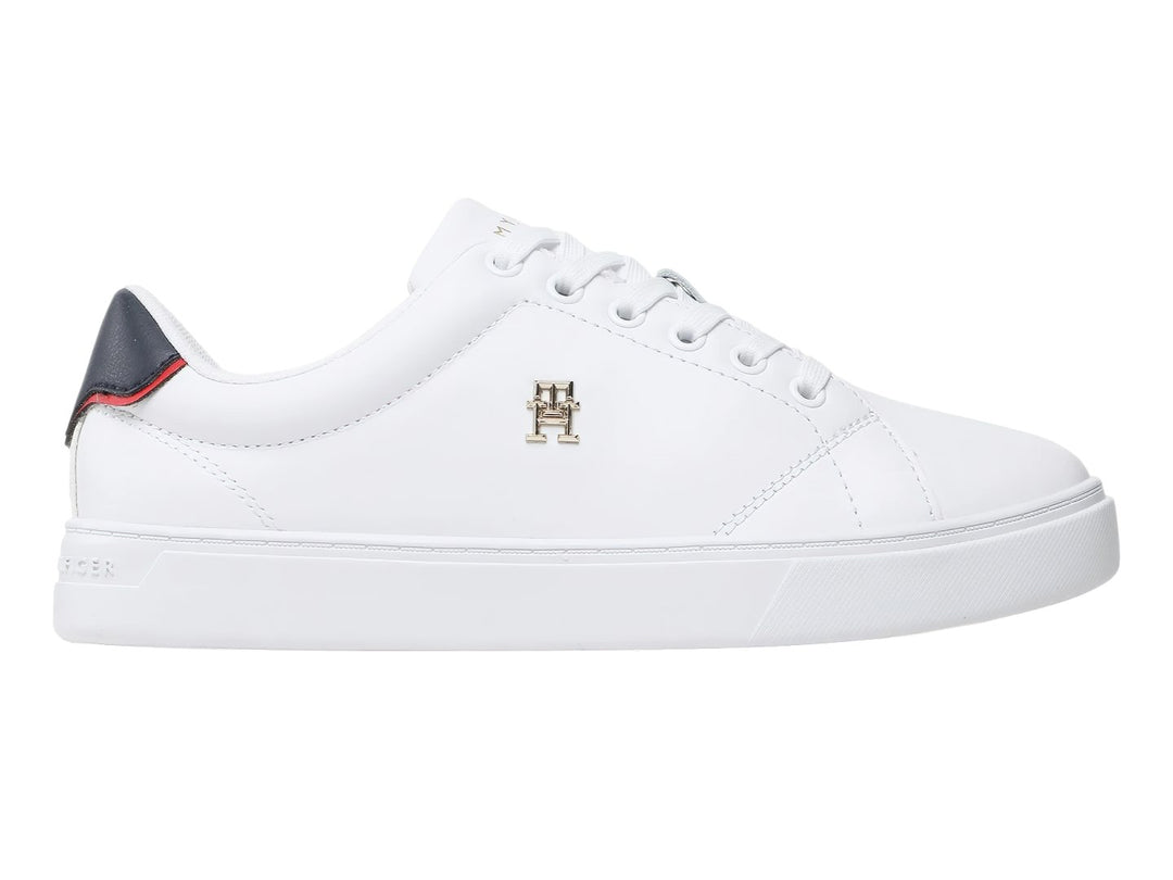 Tenis blancos Tommy Hilfiger de corte bajo con detalle azul y rojo en el talón y logo dorado lateral.