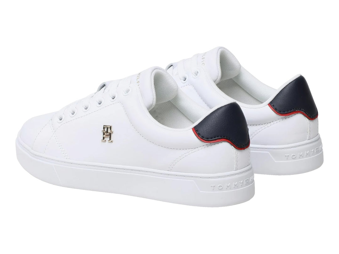 Tenis blancos Tommy Hilfiger de corte bajo con detalle azul y rojo en el talón y logo dorado lateral.