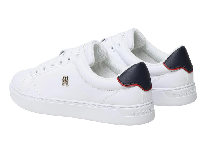 Tenis blancos Tommy Hilfiger de corte bajo con detalle azul y rojo en el talón y logo dorado lateral.