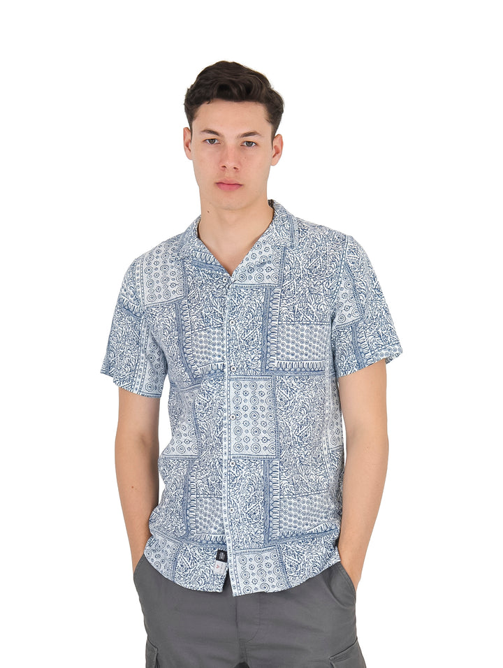 Hombre vistiendo una camisa de manga corta color azul con estampado blanco.