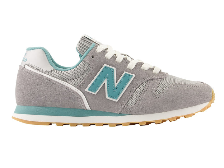 Tenis New Balance color gris con detalles en azul turquesa y suela color miel.