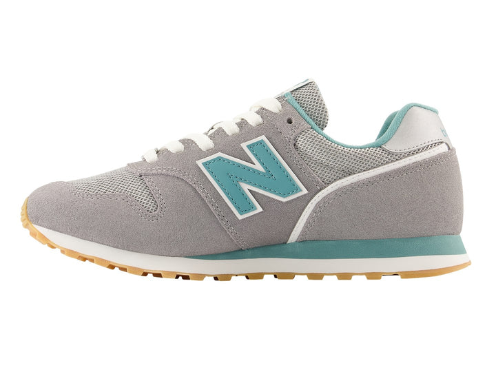 Tenis New Balance color gris con detalles en azul turquesa y suela color miel.