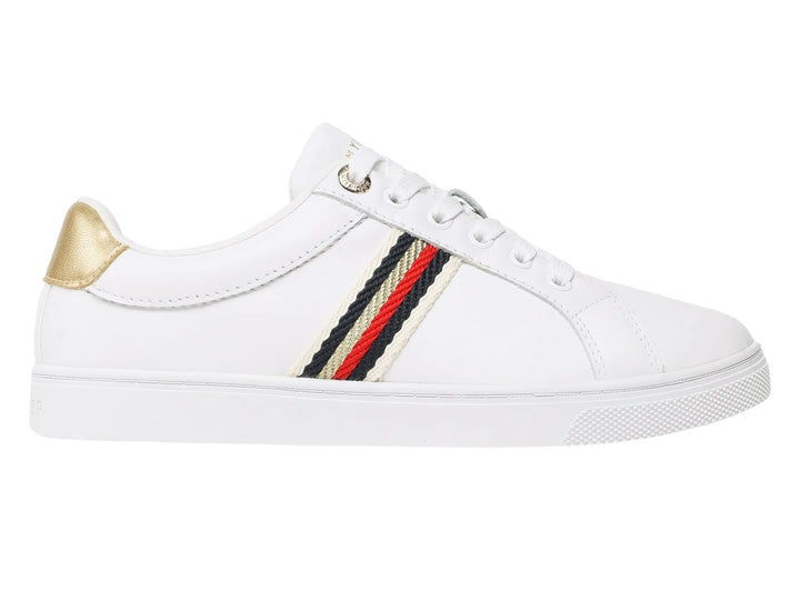 Tenis blancos Tommy Hilfiger con franja lateral tricolor y detalle dorado en el talón.