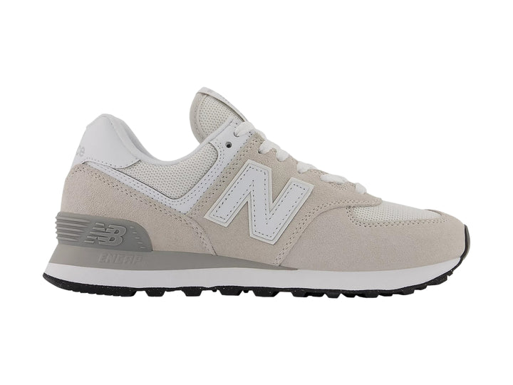 Tenis New Balance color gris con detalles en blanco y suela negra, vista lateral.