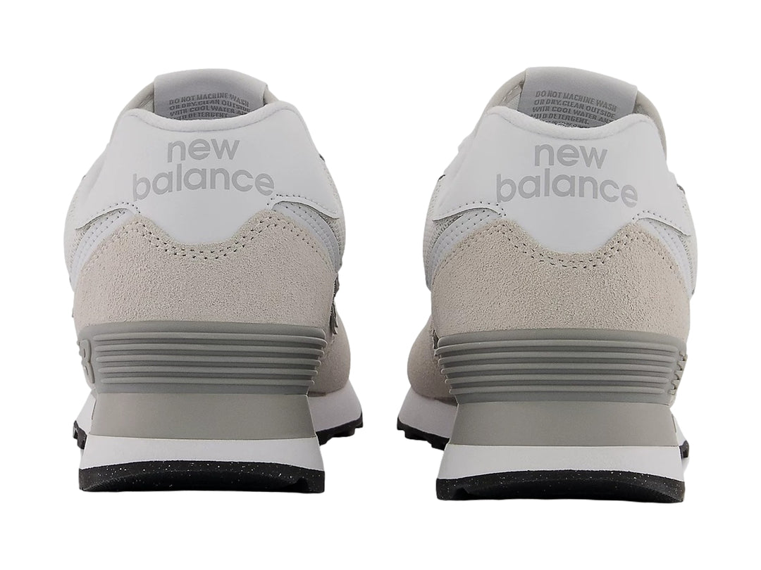 Tenis New Balance color gris con detalles en blanco y suela negra, vista lateral.