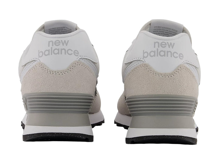 Tenis New Balance color gris con detalles en blanco y suela negra, vista lateral.