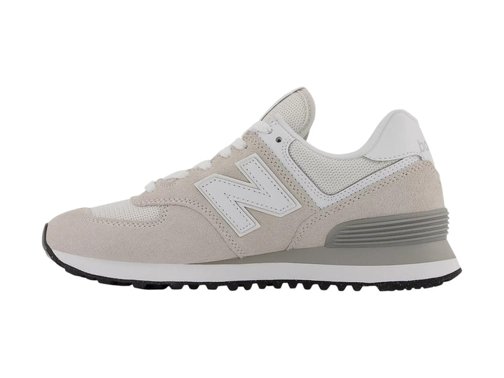 Tenis New Balance color gris con detalles en blanco y suela negra, vista lateral.