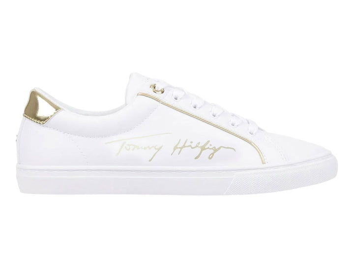 Tenis blancos Tommy Hilfiger con detalles dorados en el talón y firma lateral.