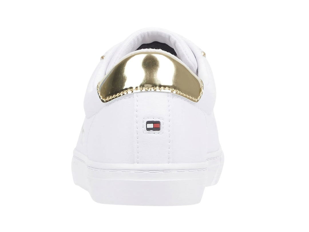 Tenis blancos Tommy Hilfiger con detalles dorados en el talón y firma lateral.