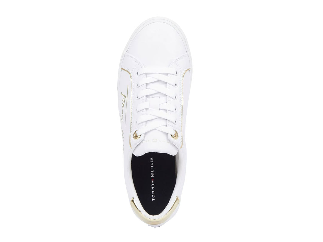 Tenis blancos Tommy Hilfiger con detalles dorados en el talón y firma lateral.