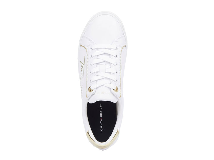 Tenis blancos Tommy Hilfiger con detalles dorados en el talón y firma lateral.