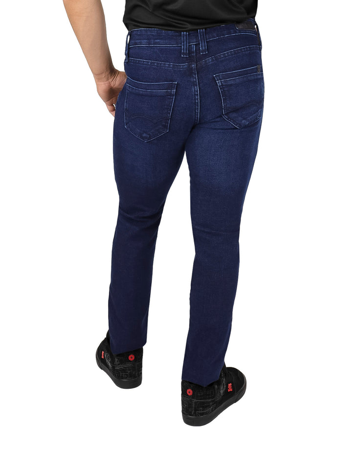 Hombre vistiendo pantalones jeans slim fit color azul índigo y calzado negro.