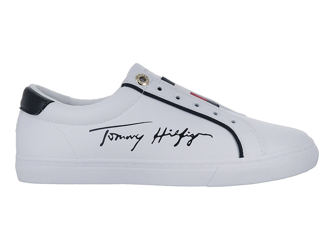 Tenis blancos Tommy Hilfiger estilo slip-on con detalles en azul marino y firma lateral.
