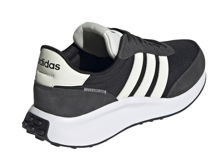 Tenis Adidas Run 70s color negro con tres franjas blancas y suela blanca.