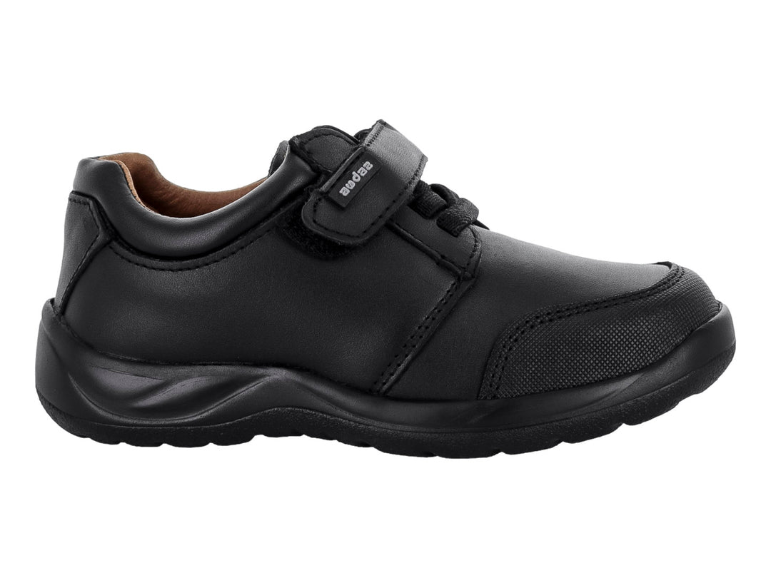 Zapato casual color negro para niño con cierre de velcro y cordones sobre fondo blanco.