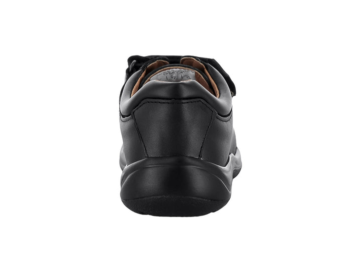Zapato casual color negro para niño con cierre de velcro y cordones sobre fondo blanco.