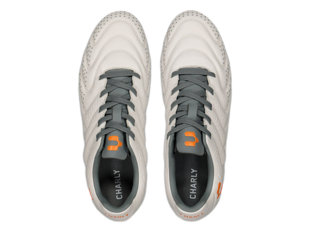 Calzado de fútbol Charly en color blanco con suela naranja y detalles en gris.
