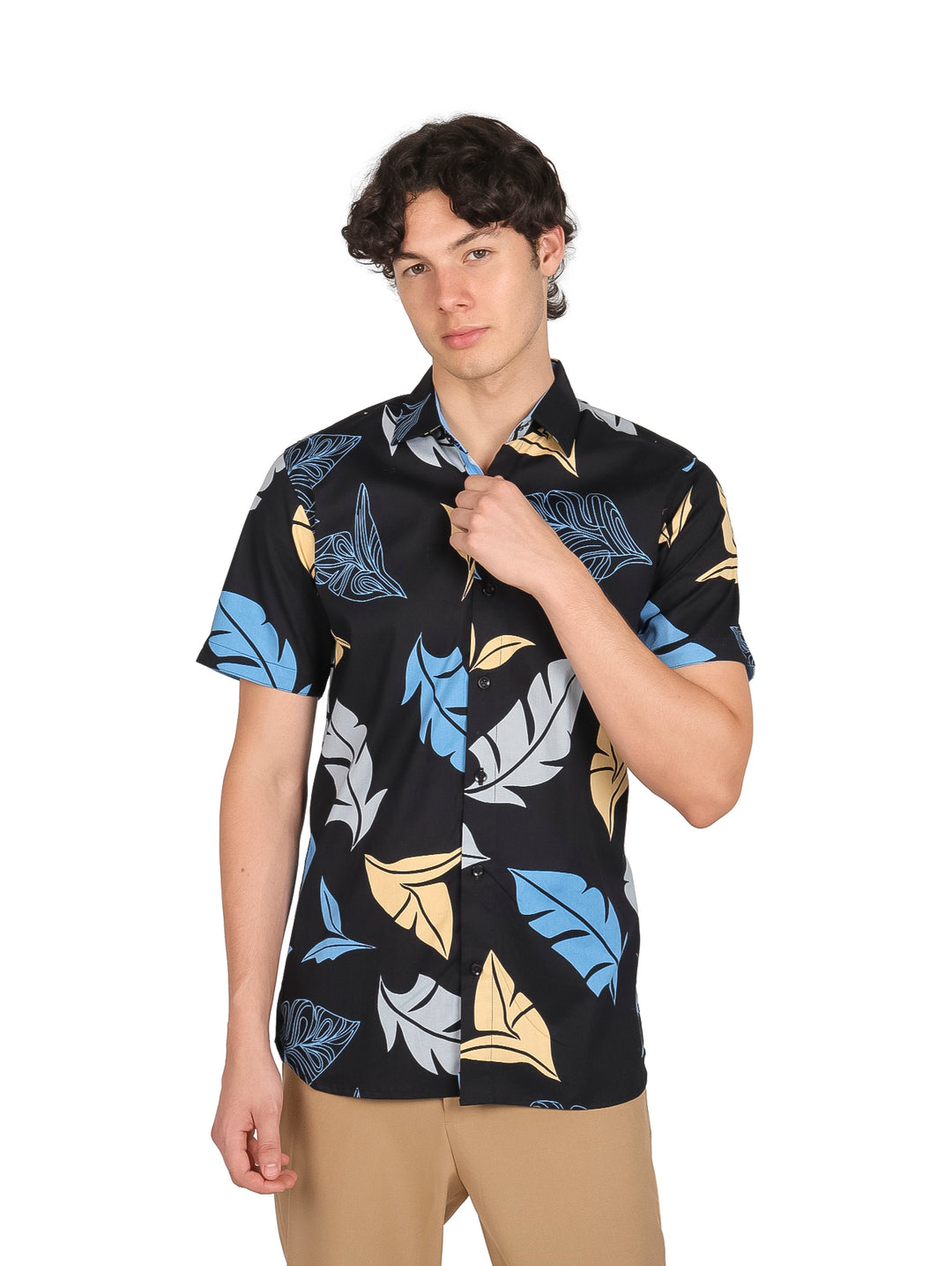 Hombre vistiendo camisa negra de manga corta con estampado de hojas en colores azul y amarillo.