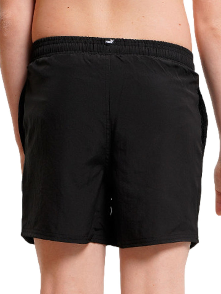 Shorts deportivos PUMA color negro con logotipo blanco y gris en la pierna izquierda, cintura elástica.