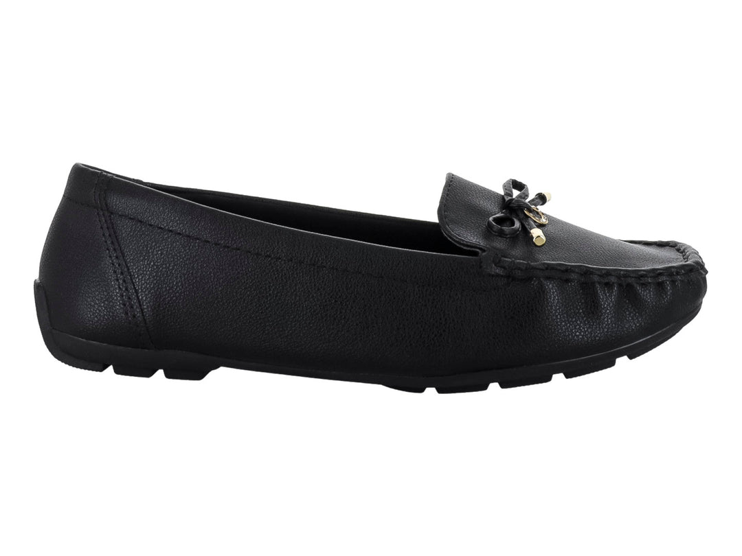 Zapato tipo mocasín color negro con textura rugosa y un lazo decorativo con detalles dorados en el empeine.