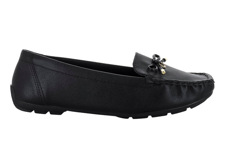 Zapato tipo mocasín color negro con textura rugosa y un lazo decorativo con detalles dorados en el empeine.