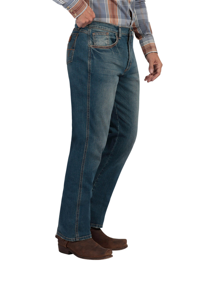 Hombre vistiendo pantalones Wrangler Stone Jeans Slim de color azul con efecto lavado.