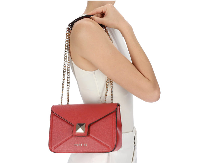 Bolso de hombro color rojo con asa superior, cadena dorada y cierre de solapa con detalle metálico cuadrado.