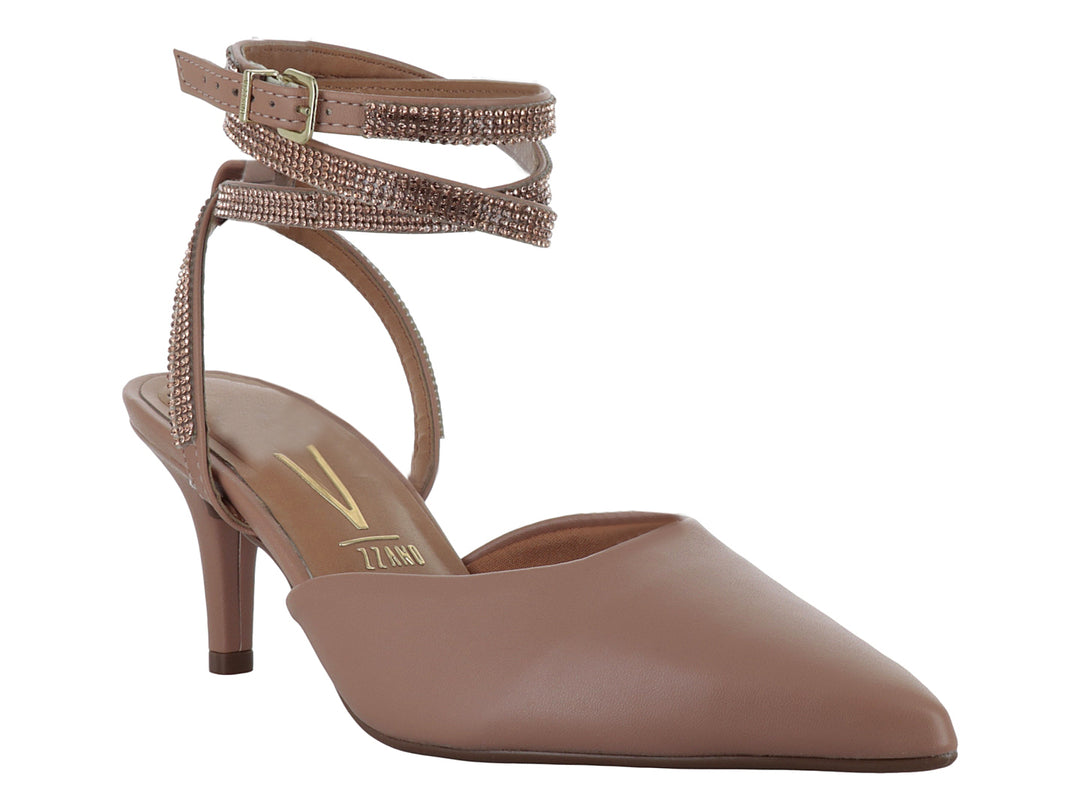 Zapato de tacón color nude con punta fina y correas brillantes al tobillo.