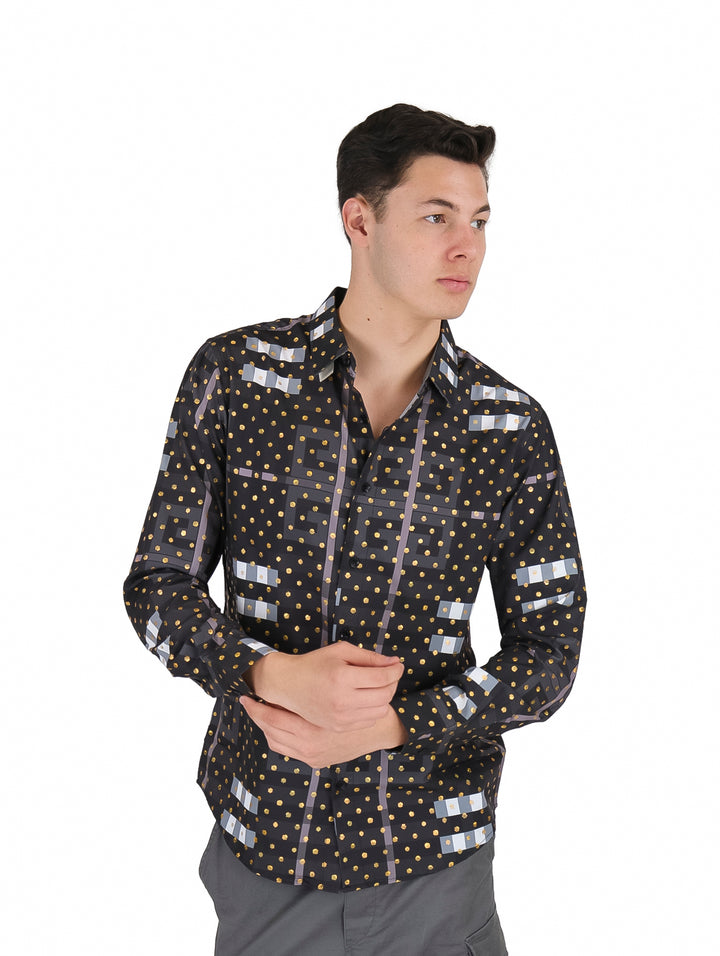 Hombre vistiendo camisa negra de manga larga con estampado de puntos dorados y figuras geométricas grises.