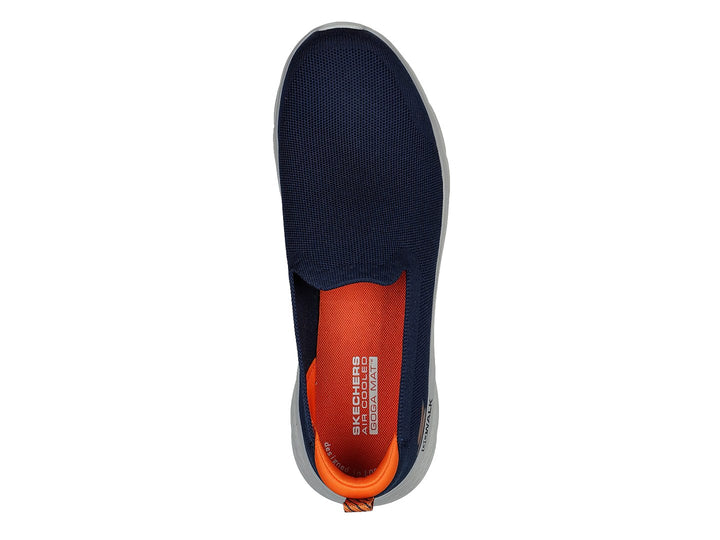 Tenis Skechers Go Walk Flex color azul marino con suela blanca y pestaña naranja en el talón.