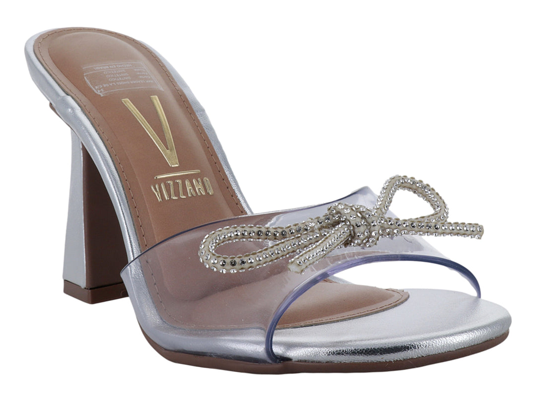 Sandalia Vizzano de tacón cuadrado color plata con tira transparente y moño decorado con pedrería.