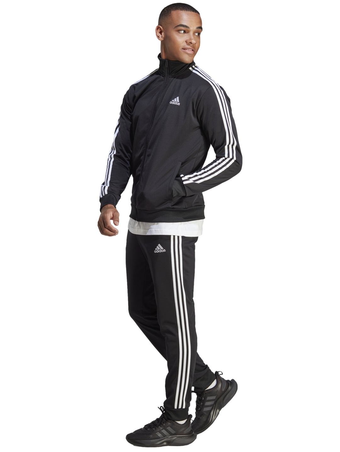 Conjunto deportivo Adidas negro con tres franjas blancas laterales, incluye chaqueta y pantalón.