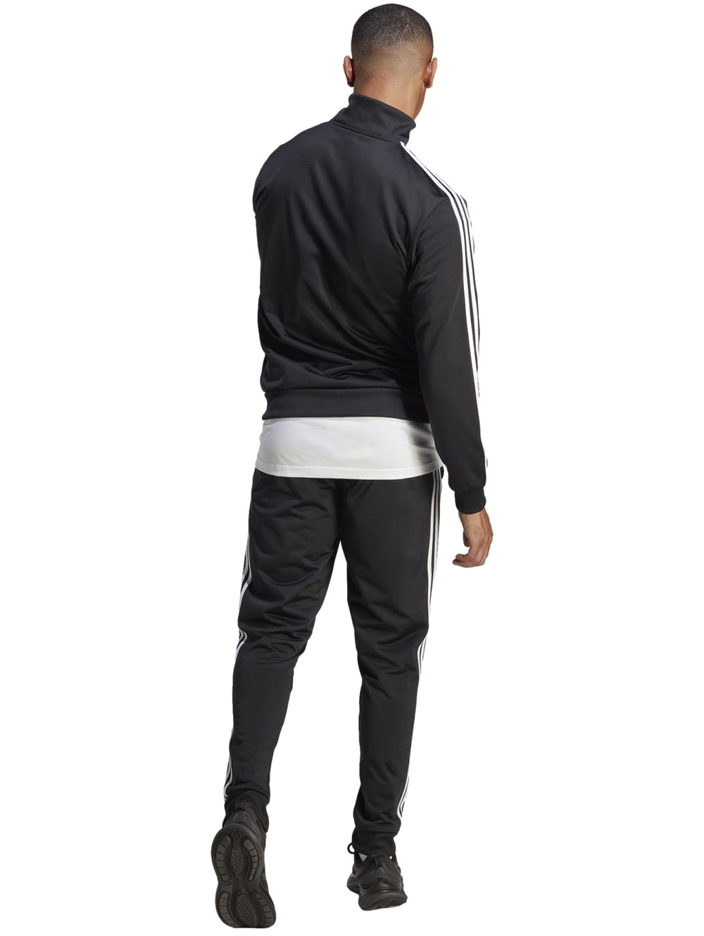Conjunto deportivo Adidas negro con tres franjas blancas laterales, incluye chaqueta y pantalón.