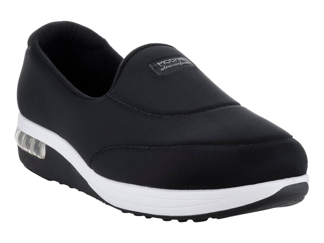 Zapato plano Modare color negro de tela lycra con suela blanca y amortiguador visible en el talón.