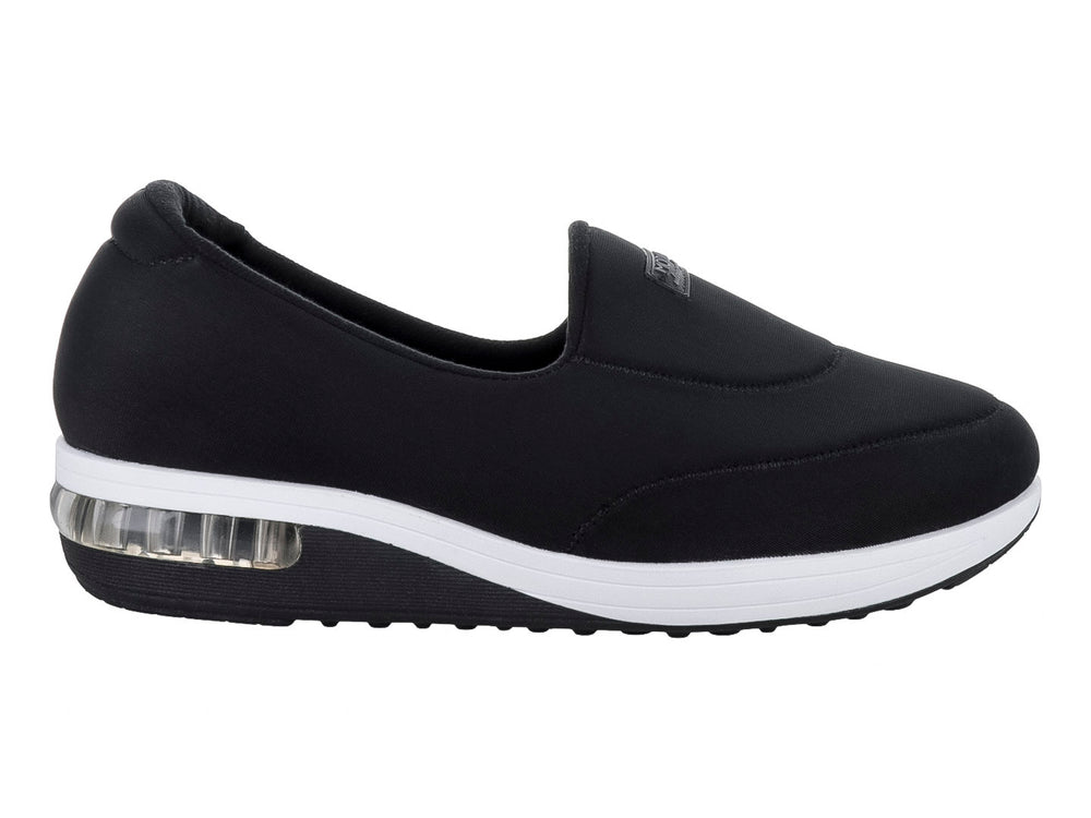 Zapato plano Modare color negro de tela lycra con suela blanca y amortiguador visible en el talón.