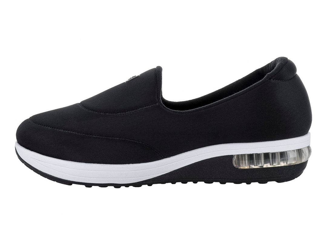 Zapato plano Modare color negro de tela lycra con suela blanca y amortiguador visible en el talón.