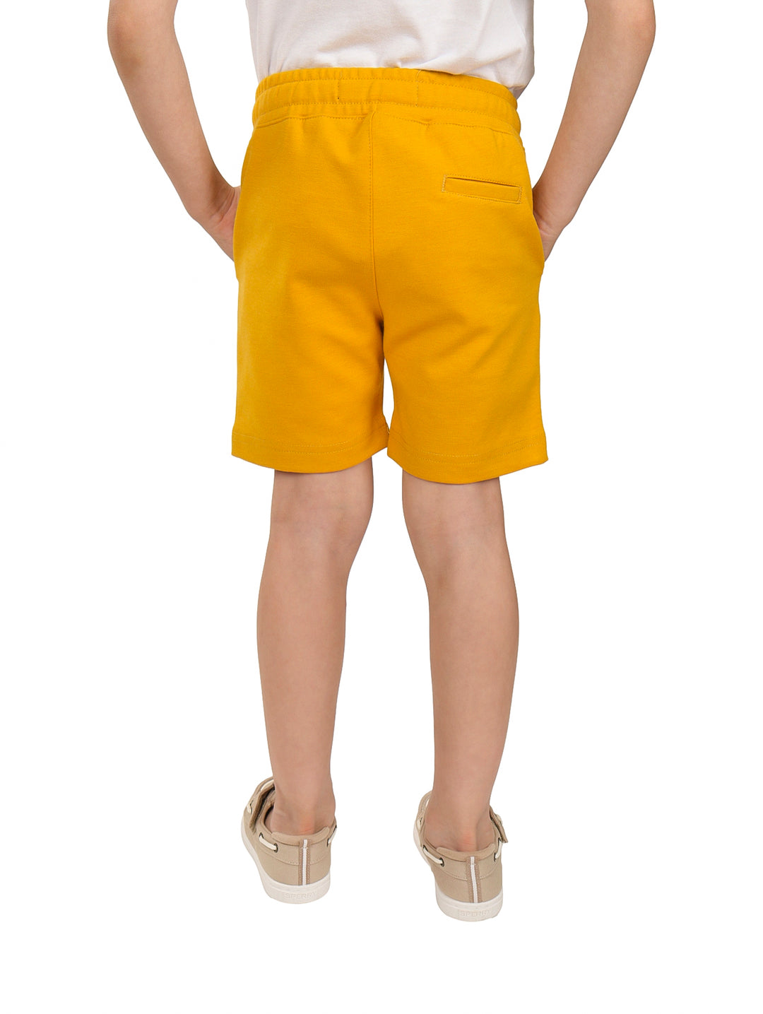 Niño vistiendo shorts color mostaza con cordón ajustable en la cintura.