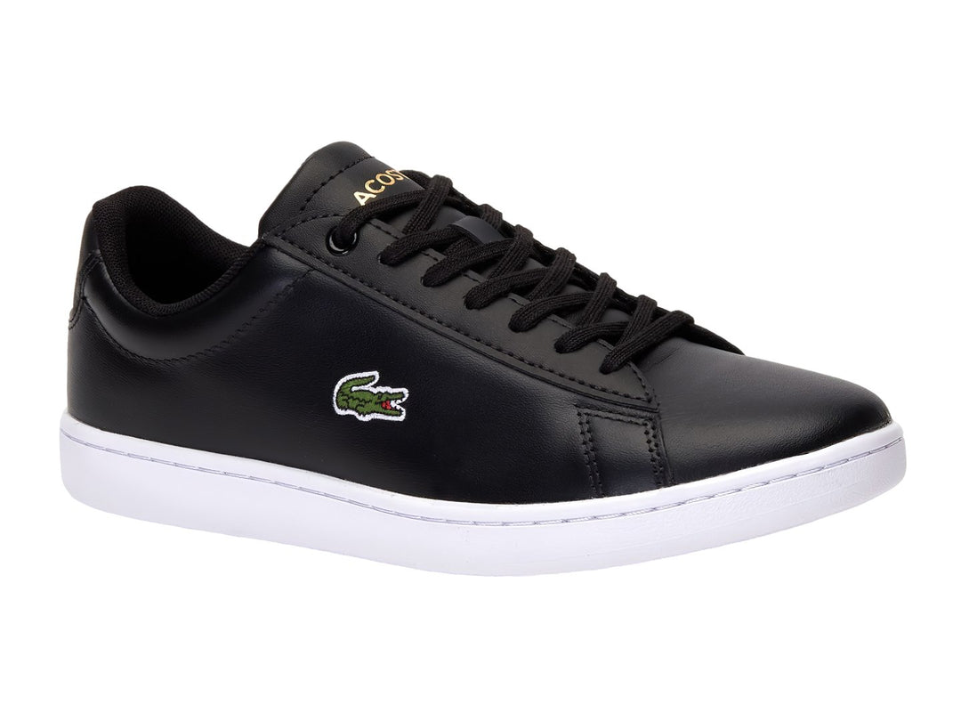 Tenis Lacoste color negro con suela blanca y logotipo del cocodrilo en el costado.