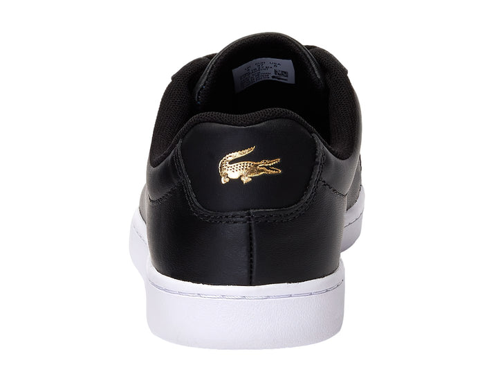 Tenis Lacoste color negro con suela blanca y logotipo del cocodrilo en el costado.
